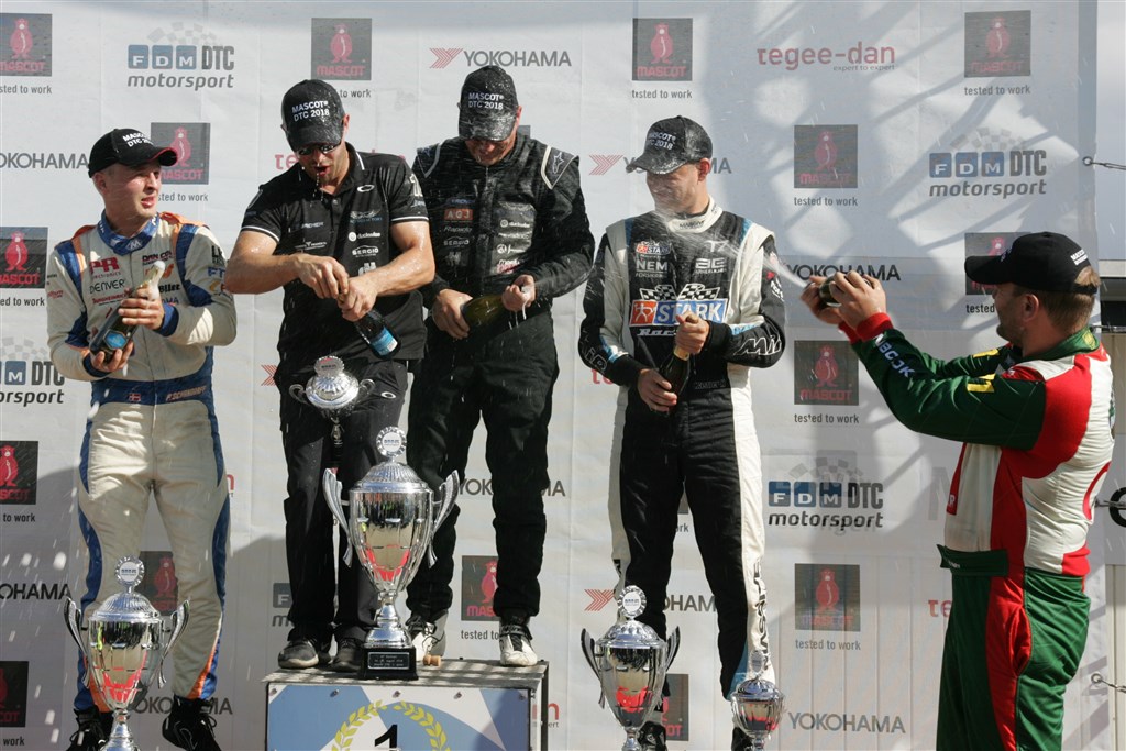 Mens en repræsentant fra Racing Factory, vinderen Ronnie Bremer og treeren Kasper H. Jensen i midten kæmper med champagneproppen, sørger løbets toer Frederik Schandorff og vinderen af MASCOT Cuppen Henrik Nøhr for, at de blev våde
(Foto: Henning Smed)